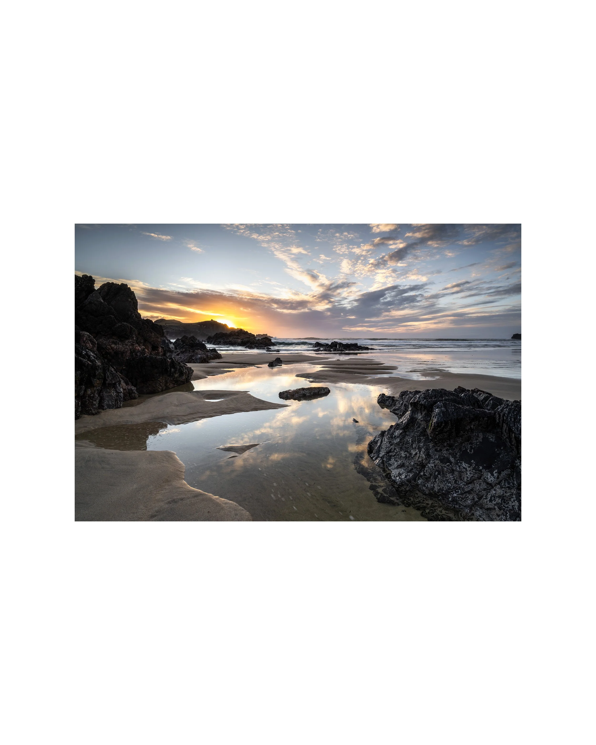 Mangersta Beach on the Isle of Lewis showing rock pools, soft reflections and warm coastal light across the shoreline.