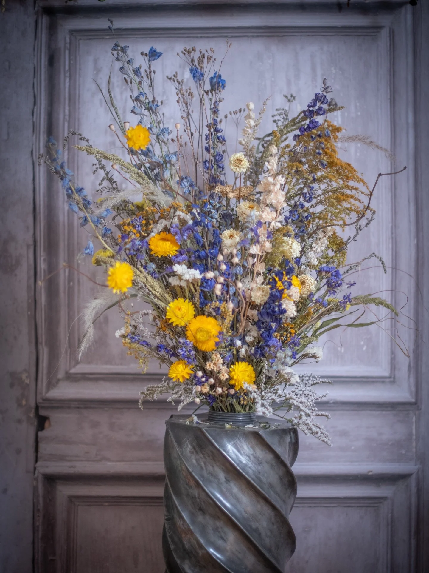 A bright display of dried flowers to bid farewell 💙🤍💛
.
I was honoured to be asked by a previous customer to make this arrangement for her mother&rsquo;s funeral. She sent me the vase- a very striking pewter urn that had belonged to her father, so