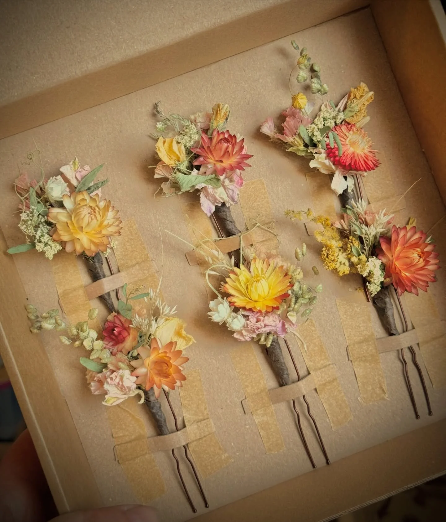 A pretty set of dried flower hair pins for bridesmaids; each one a little different 🧡  The palette of soft greens, pinks, peaches and yelllow; the curly tendrils and the whispy grasses were all inspired by the stunning proposal by the couples floris