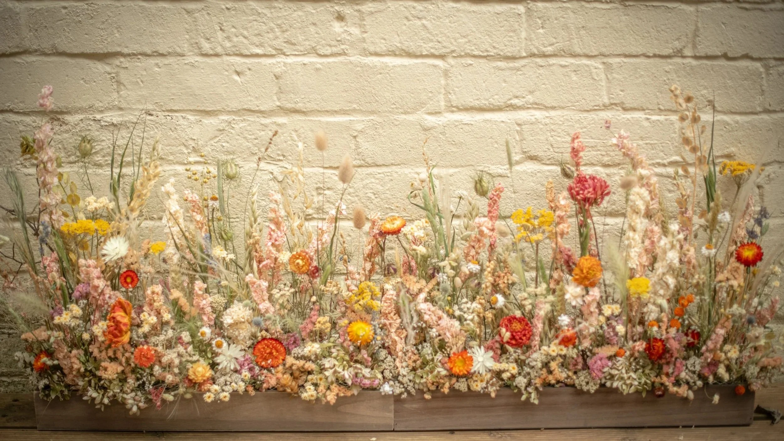 dried flower meadow boxes for a top table or ceremony centrepiece warm tones of coral yellow pink and orange with soft green grasses for a natural look