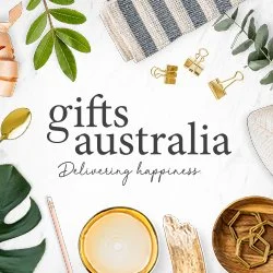 Array of gift items including plants, a glass of drink, wooden and ceramic decor, and gold clip clips on a white background with text 'gifts australia delivering happiness'.