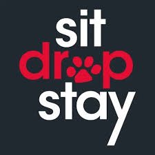 A poster with the words 'sit', 'drop', and 'stay' in bold white and red text on a black background, with a paw print inside the letter 'o' in 'drop'.