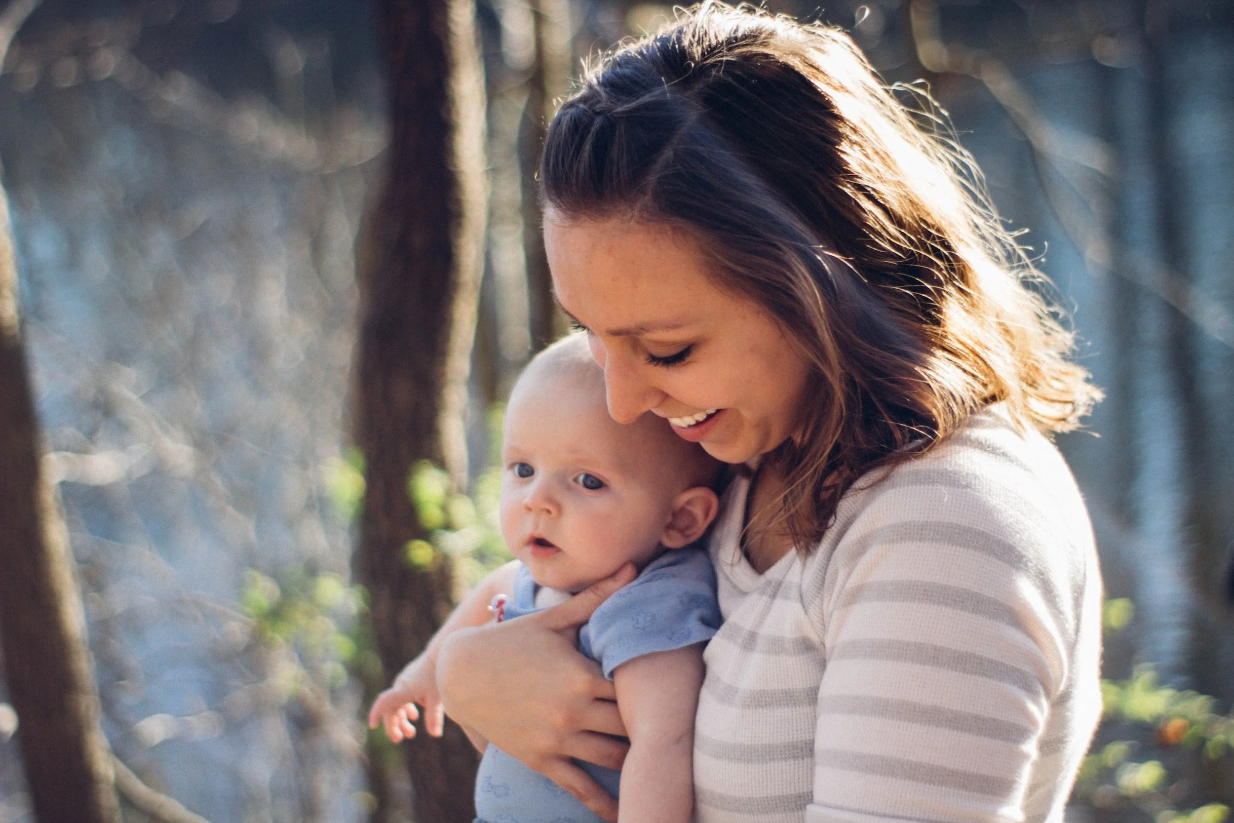 Mom holding a baby and smiling