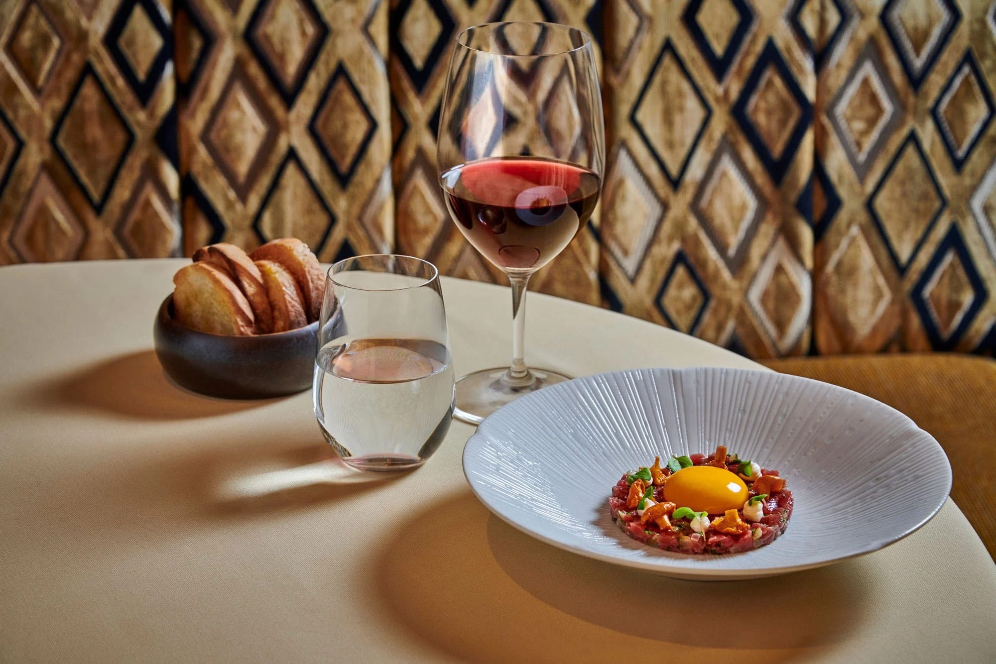 View West Photography | hotel photographer | resort photographer hotel photography | Matfen Hall Hotel | food photograph of steak tartar with an egg yolk accompanied with a glass of red wine and toasted bread | Northumberland | North East England.jpg