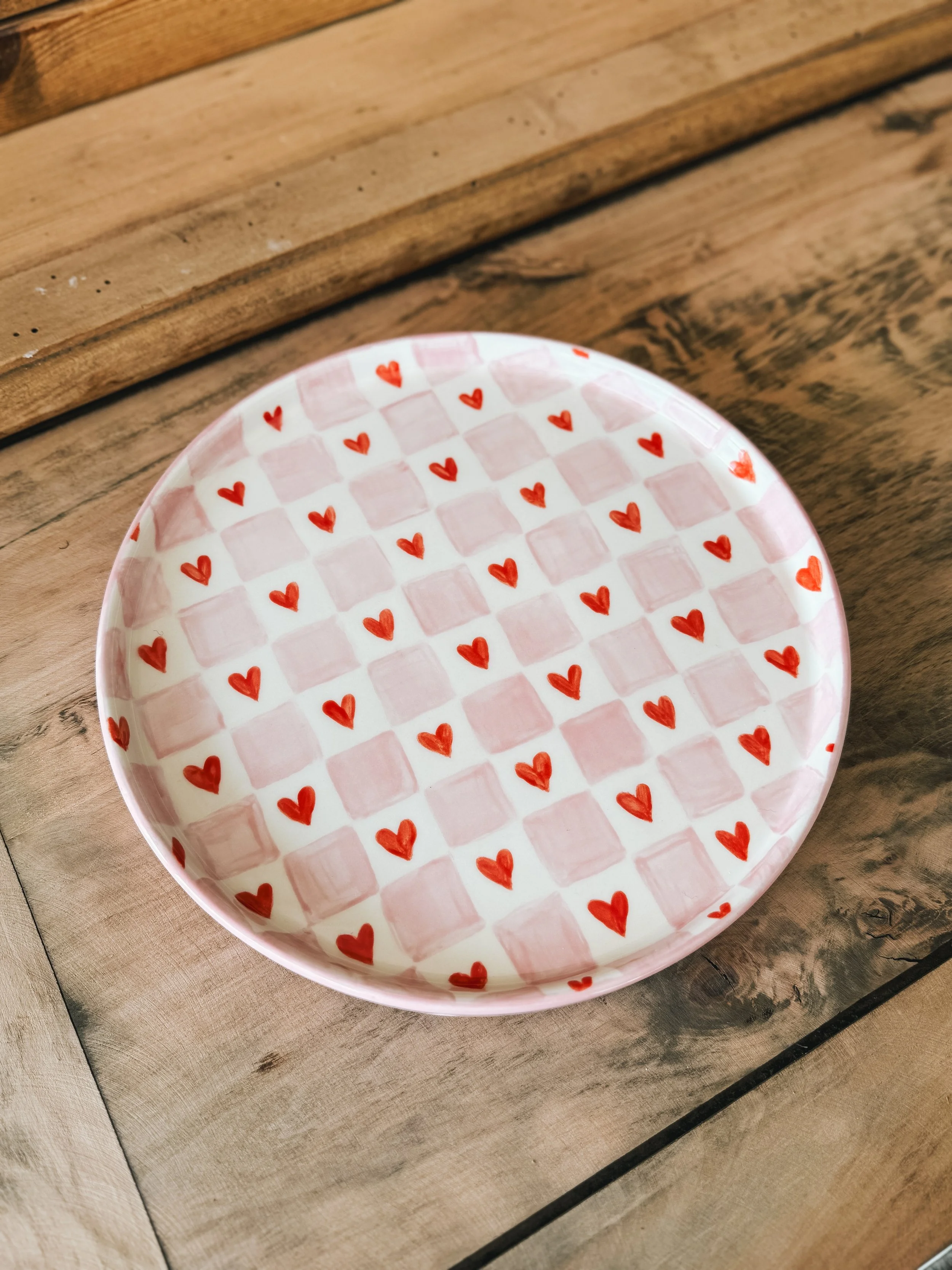 Grande assiette illustrées avec des carreaux rose et des coeurs rouge.
