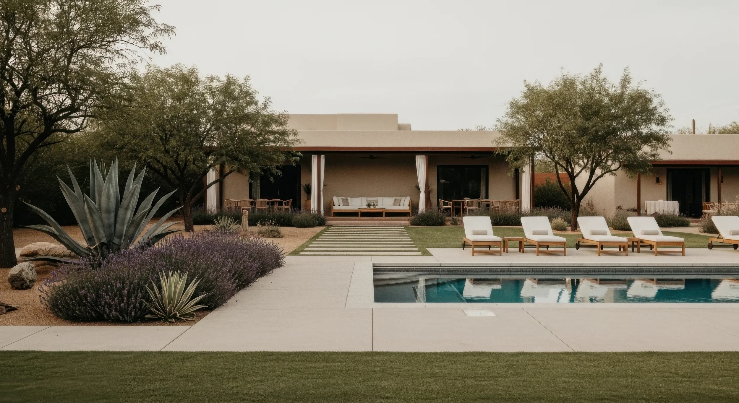 Casa moderna con porche y muebles de exterior, piscina y jardín con árboles y plantas