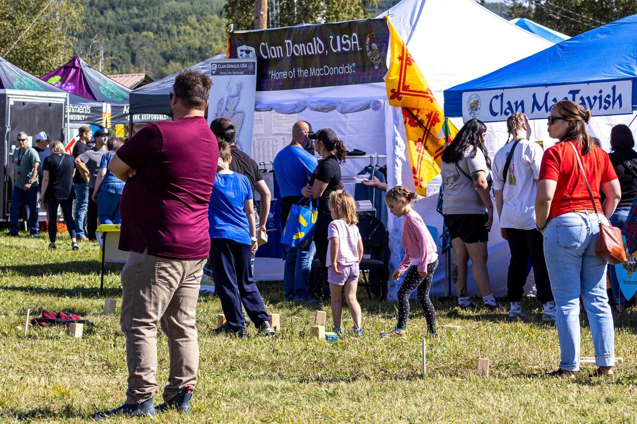 Crowds gather around the Clan booths, learning about tradition and heritage under the midnight sun.