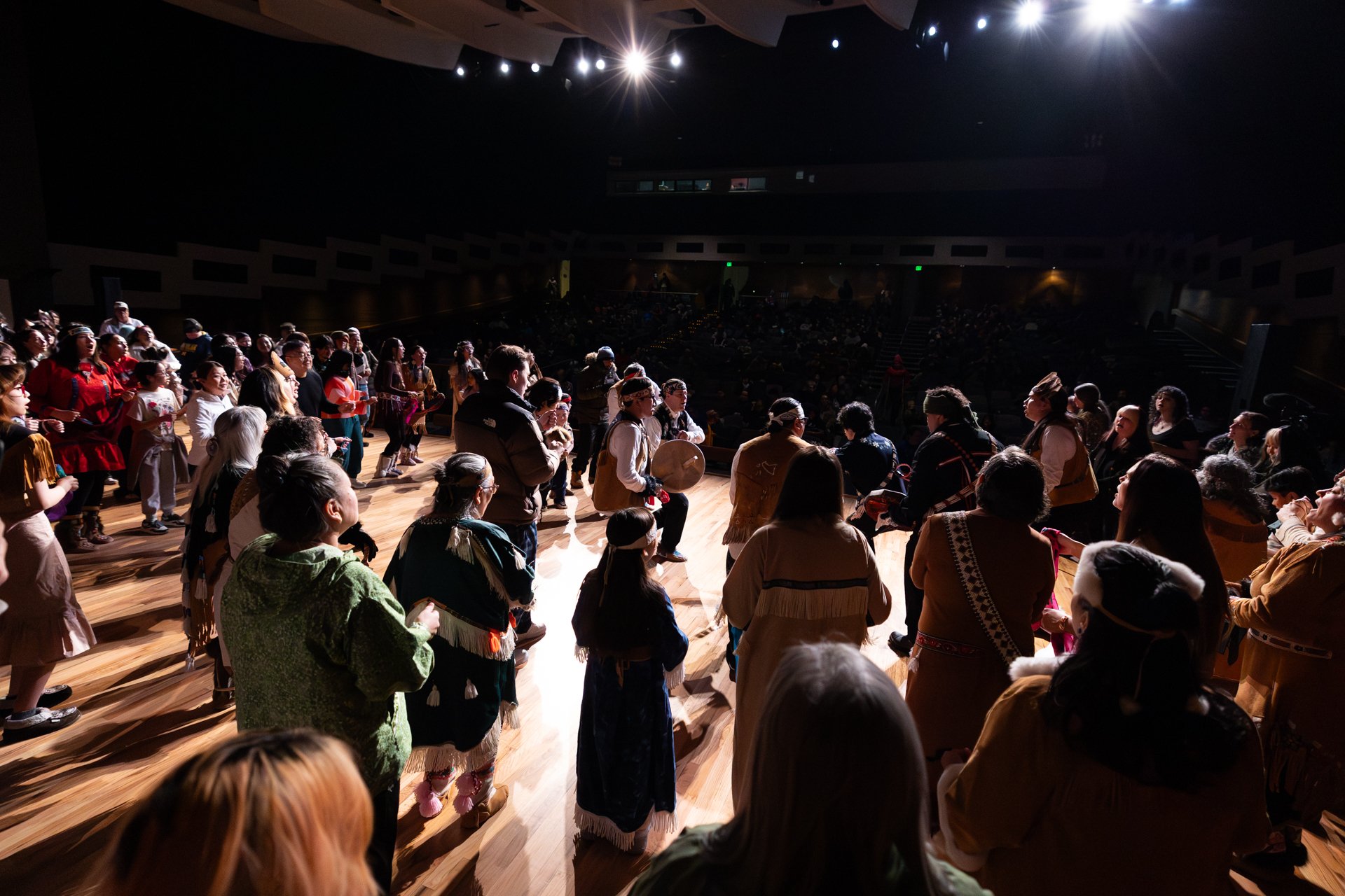 Photo by Elvie Underwood - Audience members join the Dene Eslaanh' dance group in the invitational song on Feb. 28, 2026.