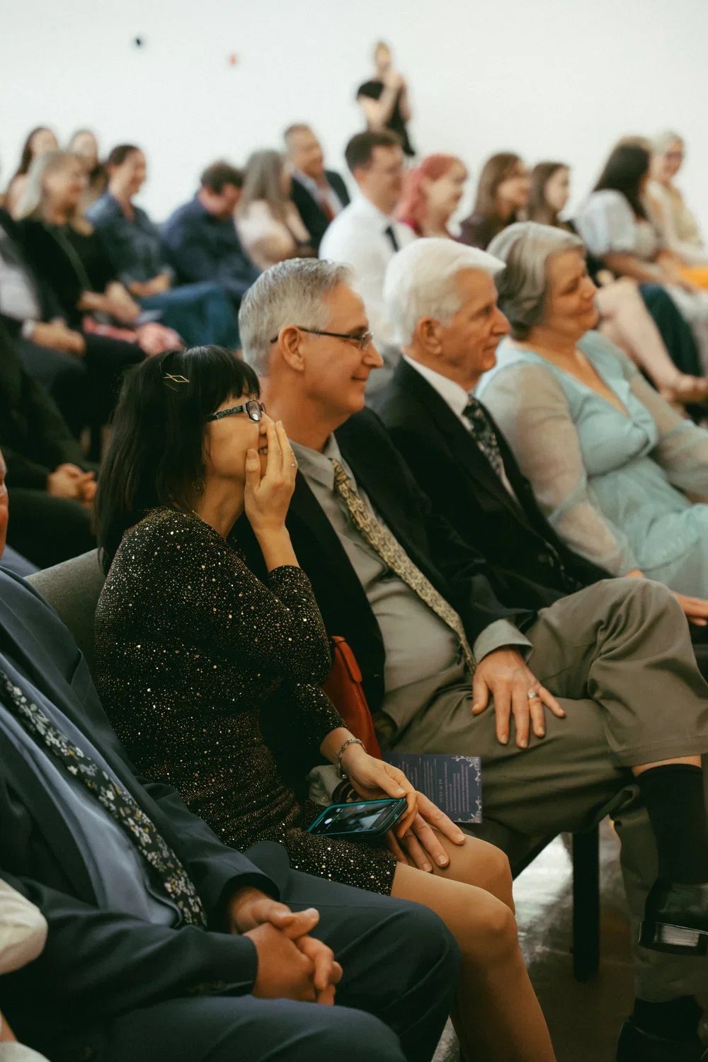 Group of people attending a formal event, seated and listening attentively