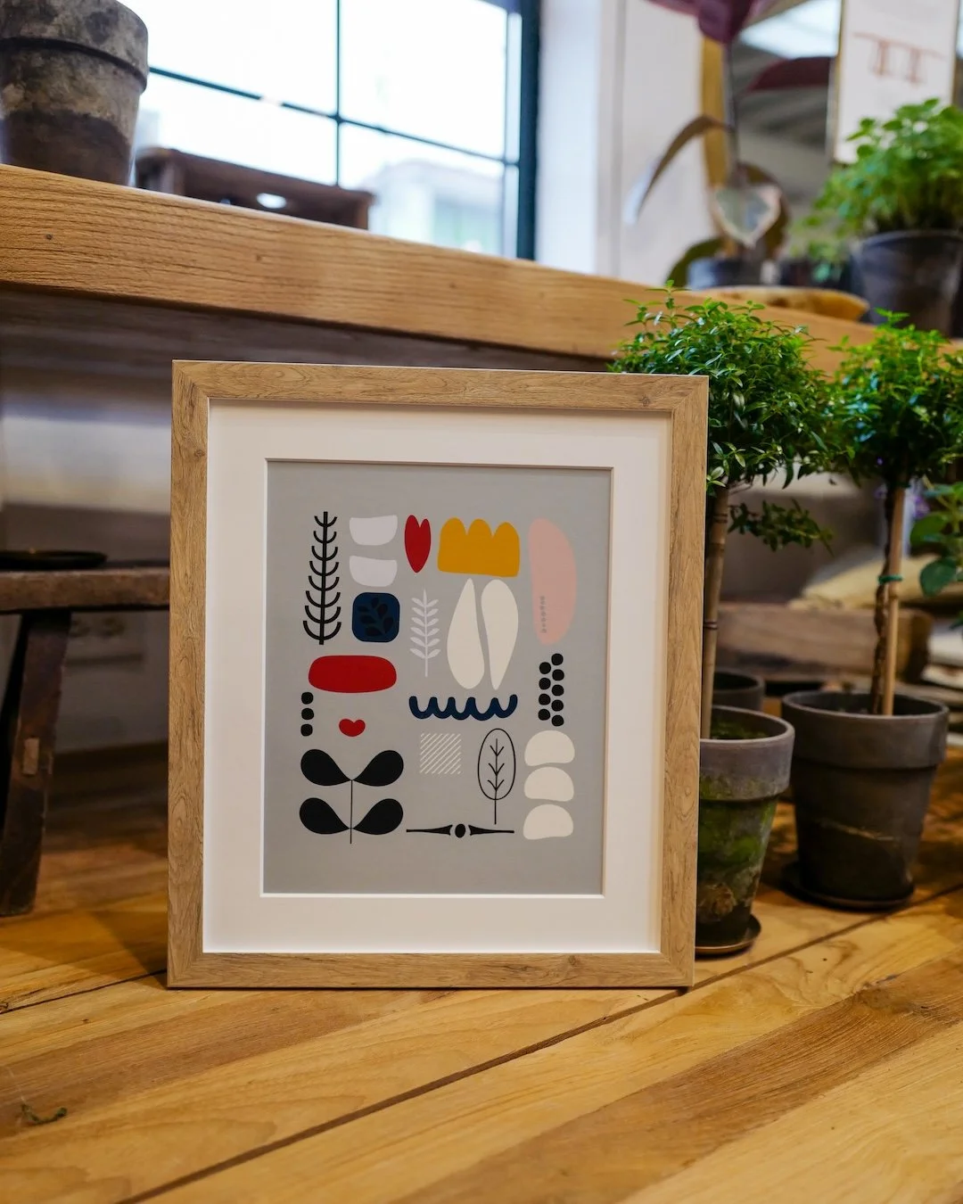 Modern art, meet modern framing. Clean lines, natural wood and a sophisticated touch that lets bold shapes and colors shine. #customframing #customframes #modernart #printandframe #woodframe #moderndecor #midcenturymodern #framewhatyoulove #lovewhaty