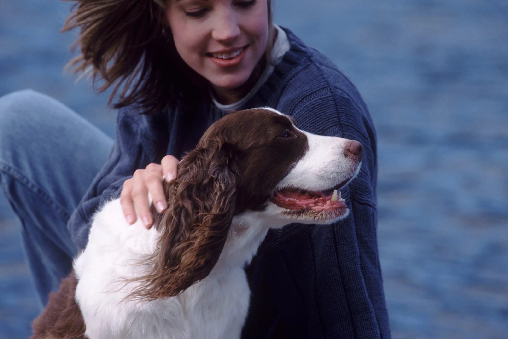“Young woman looking into the eyes of an English Springer Spaniel dog.”