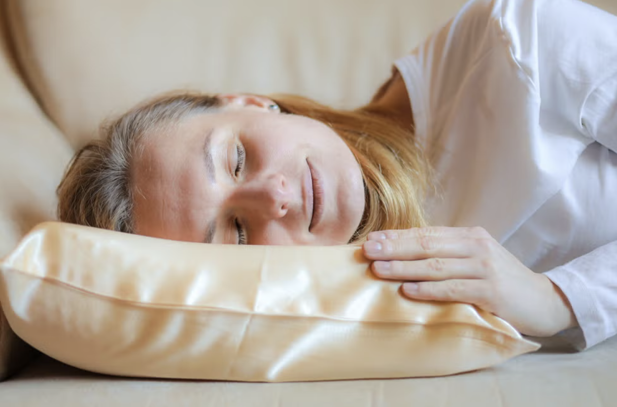 photo of a woman sleeping on silk pillow used to illustrate how you can protect hair against frizz