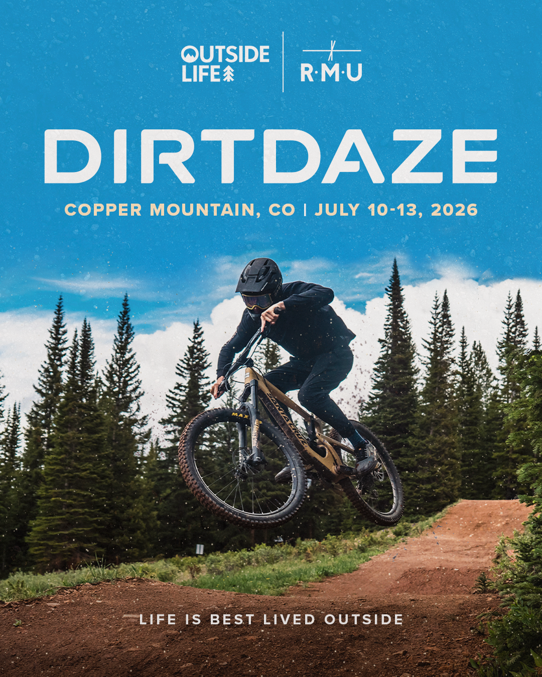 A mountain biker in black riding gear and helmet jumping on a dirt trail with trees and clouds in the background.