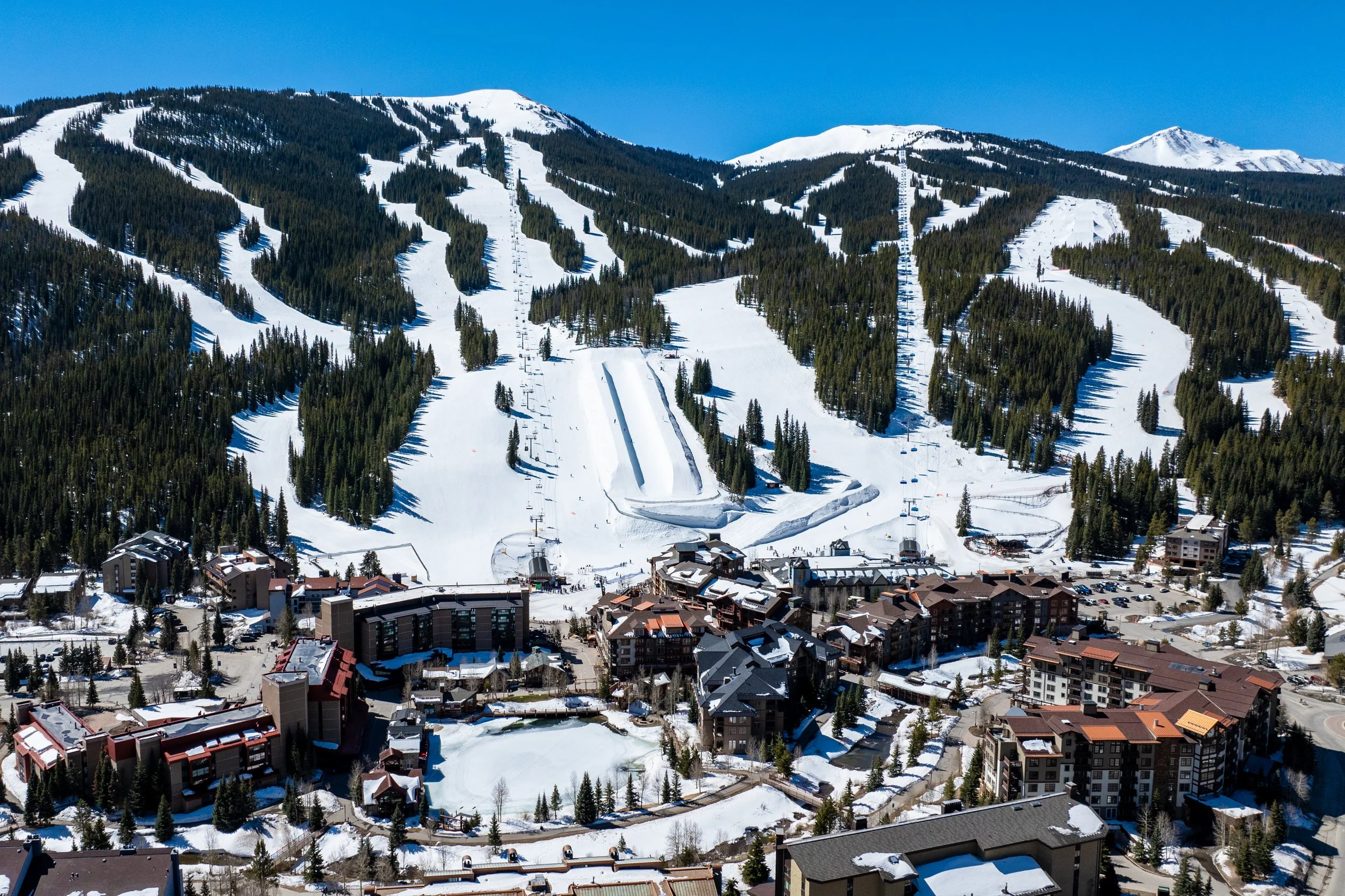Aerial view of snow-covered mountainous landscape with ski slopes and ski lift, overlaid with the text 'OLX', 'Aomori Japan', and 'Curated by Kaitlyn Farrington'.