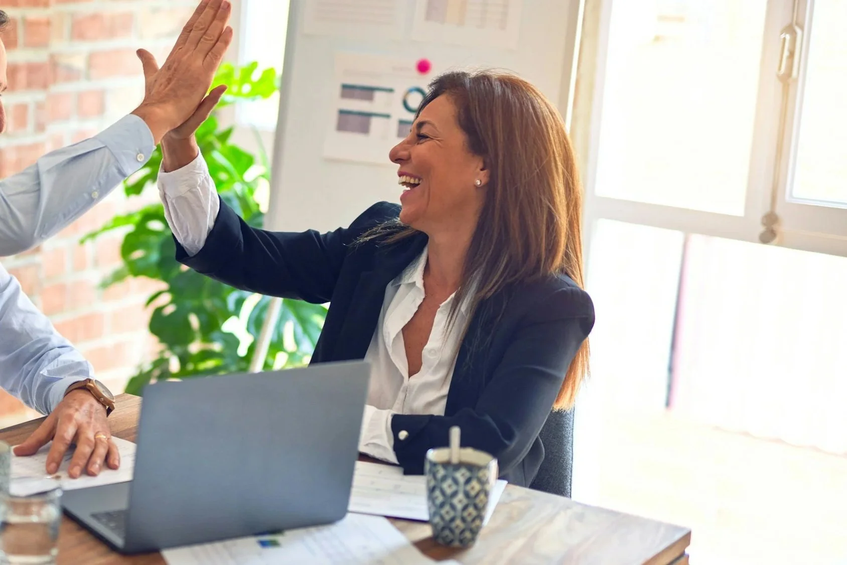 woman being high-fived inside an office
