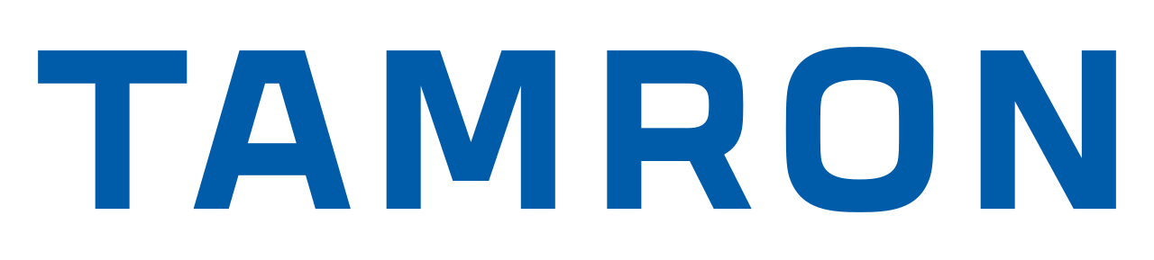 The image displays the word 'TAMRON' in large, bold, capital blue letters.