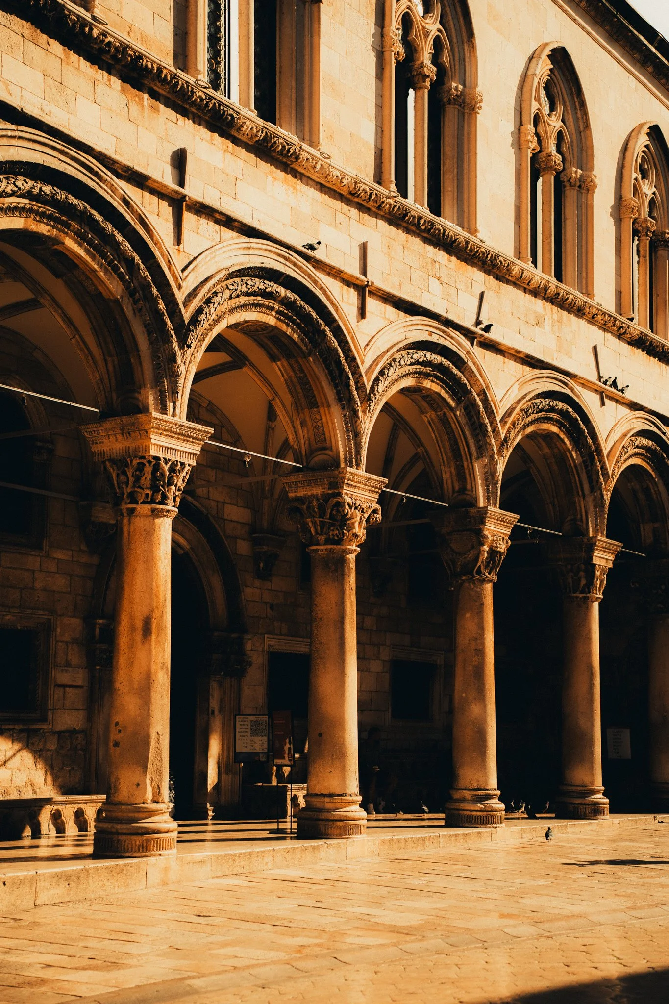 Historical building with arched windows and ornate columns, captured during golden hour.