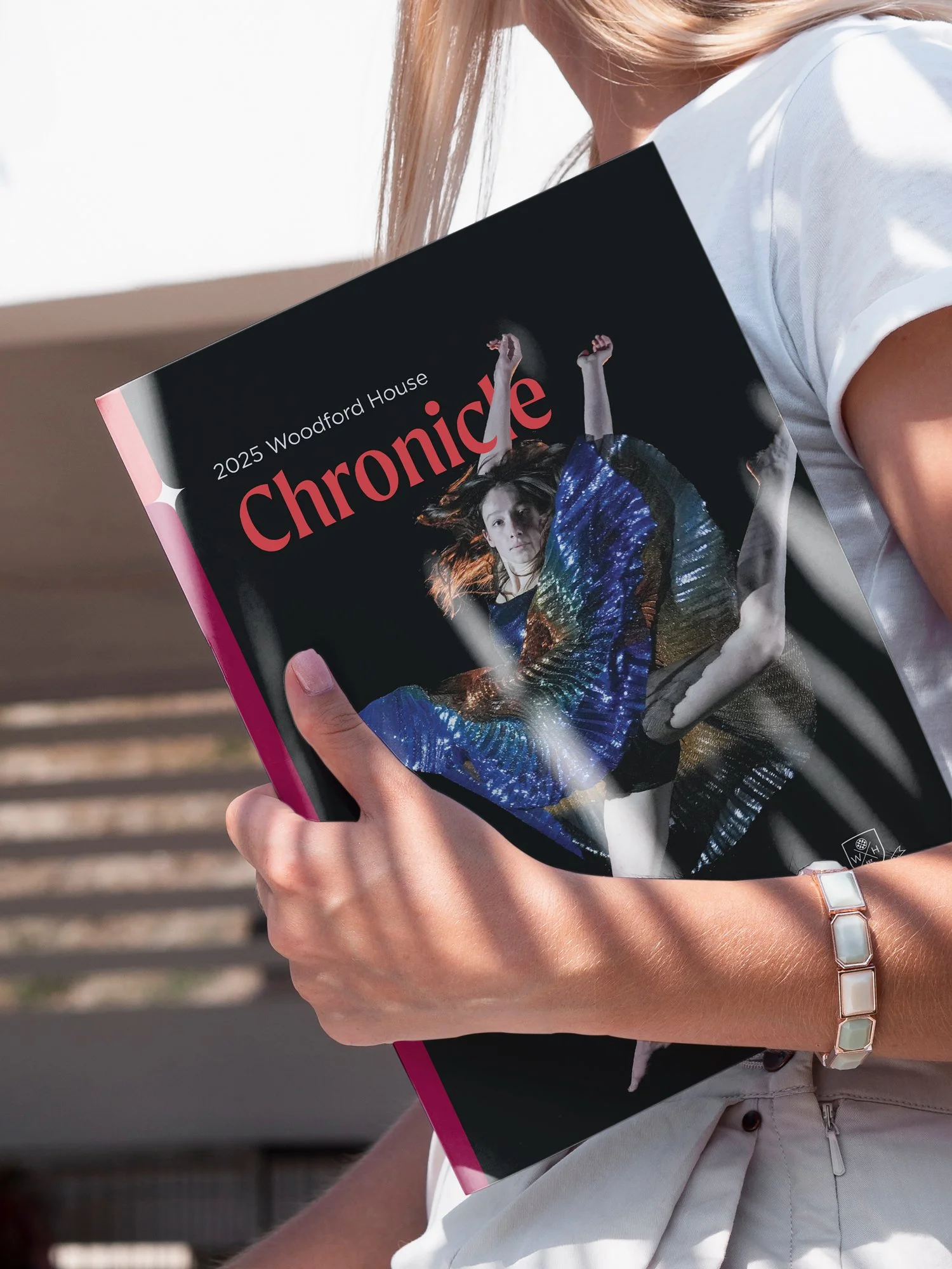 Close up of young woman holding 2025 edition of Woodford House Chronicle