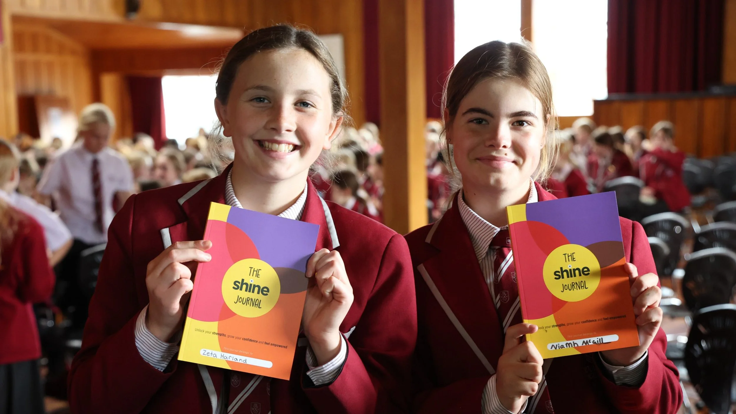 Two Woodford House students holding their Shine Journals