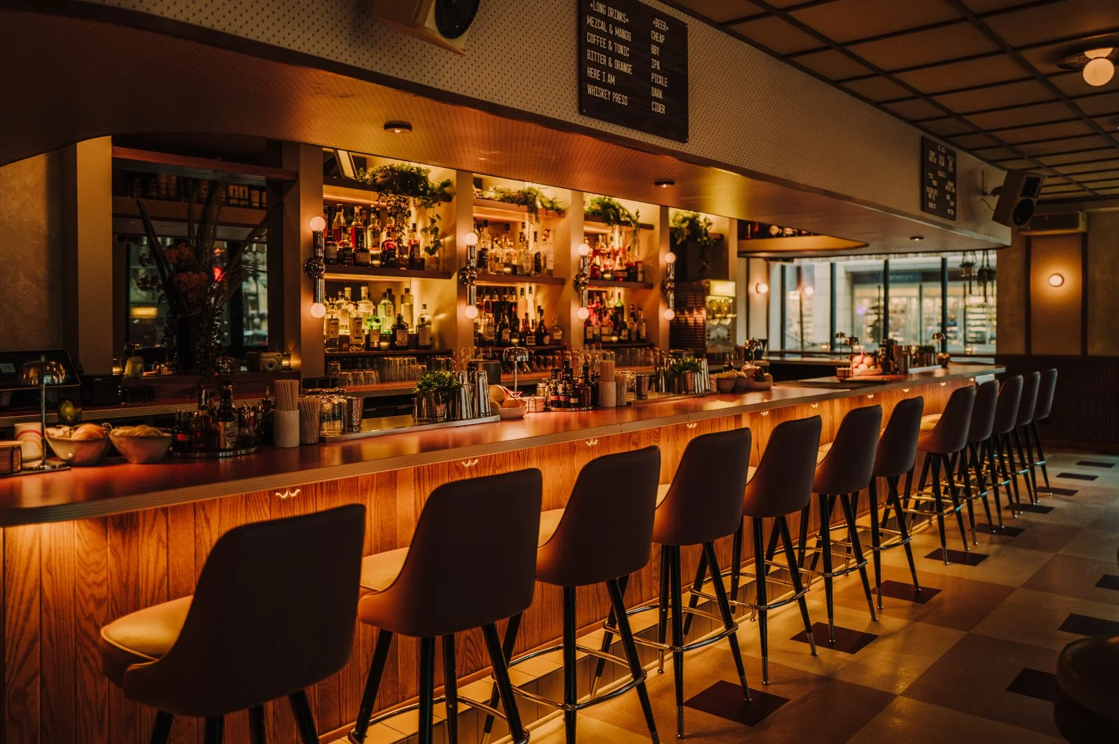 Double Fun interior bar view with illuminated shelving, bar stools, and warm tones by Siren Betty Design.