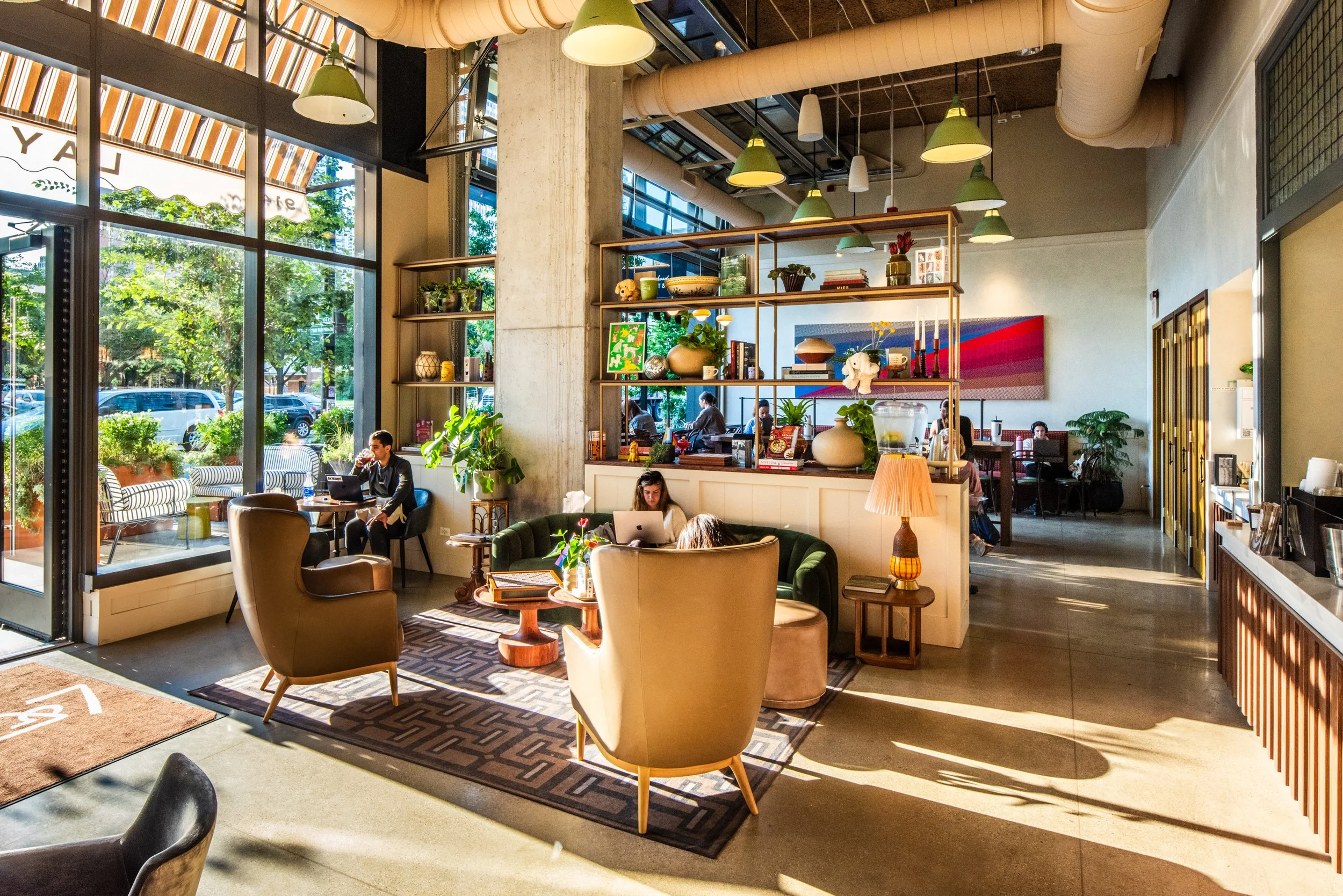 Layla and Ringo’s interior lounge with layered seating, open shelving, large windows, and warm daylight by Siren Betty Design