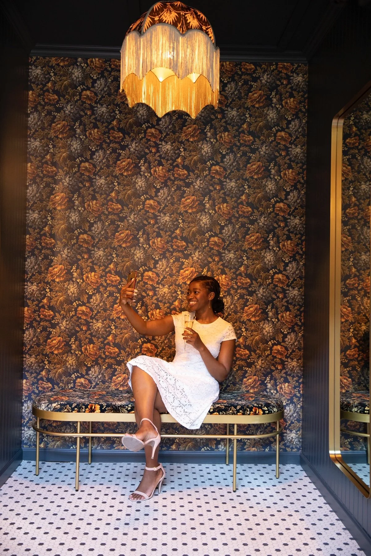 Portrait lounge nook with vintage floral wallpaper and gold lighting at Wildman BT by Siren Betty Design.
