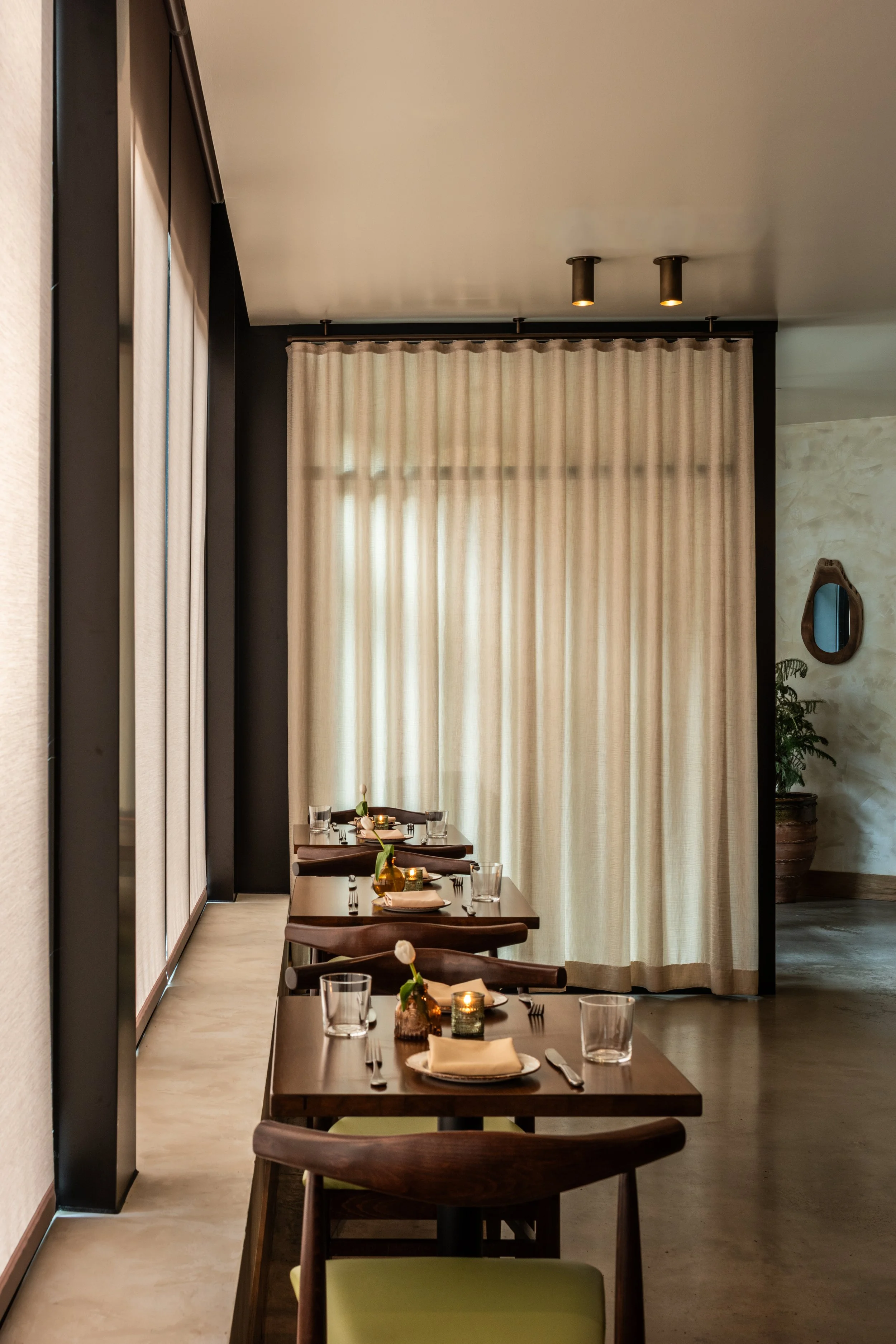 Intimate Burl restaurant dining area with sheer drapery, walnut furniture, and softly layered hospitality design by Siren Betty Design.