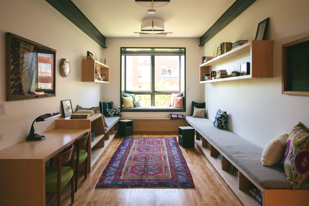 Library nook at The Publishing House with built-in banquette seating, custom desks, floating shelves, vintage rugs, and curated artwork by Siren Betty Design.