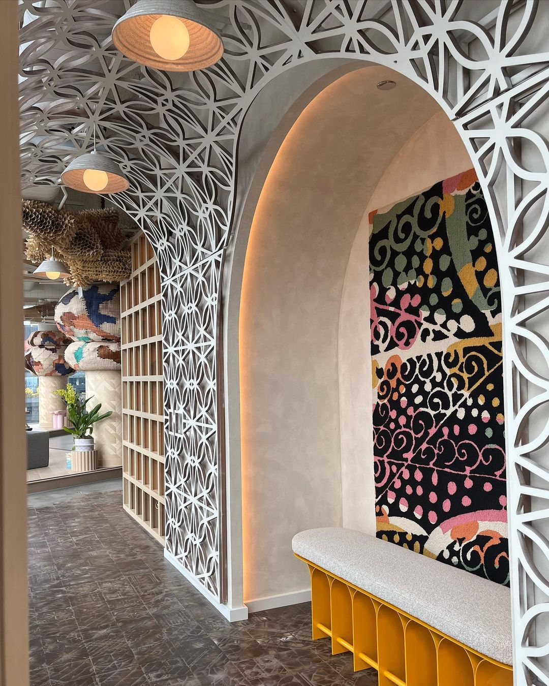 Arched hallway nook at Good Chaos by Siren Betty Design with geometric bench, patterned tapestry, and sculptural ceiling art