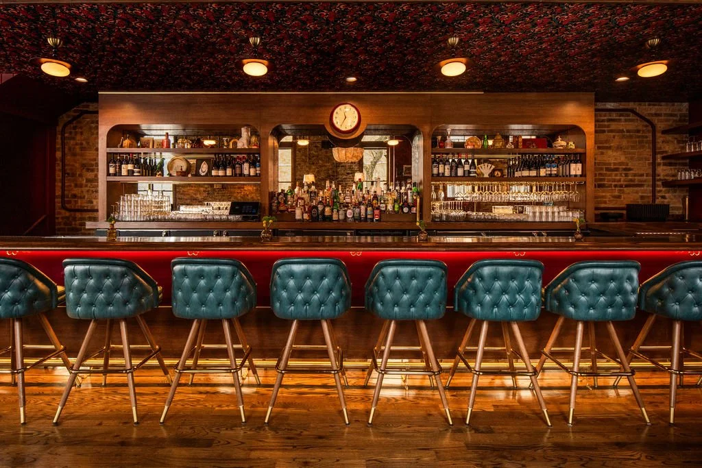 Full bar elevation with teal tufted stools at Dimmi Dimmi by Siren Betty Design.