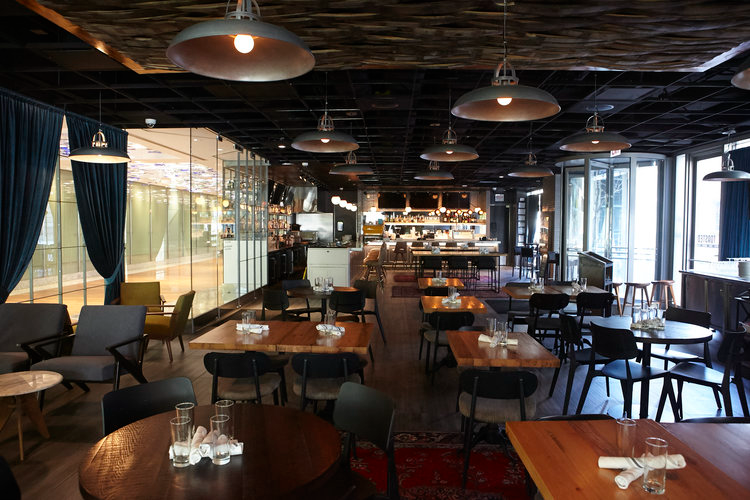 Slightly Toasted interior featuring warm lighting and layered seating in modern tones by Siren Betty Design.