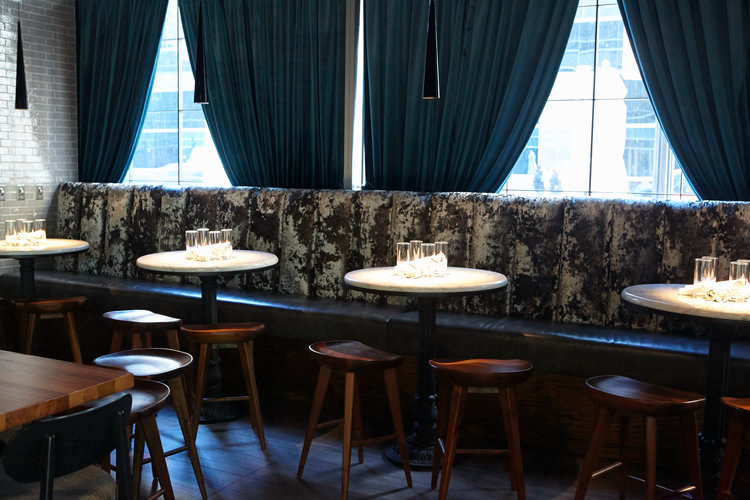 Slightly Toasted intimate seating area with marble tables velvet banquettes and pendant lighting by Siren Betty Design.