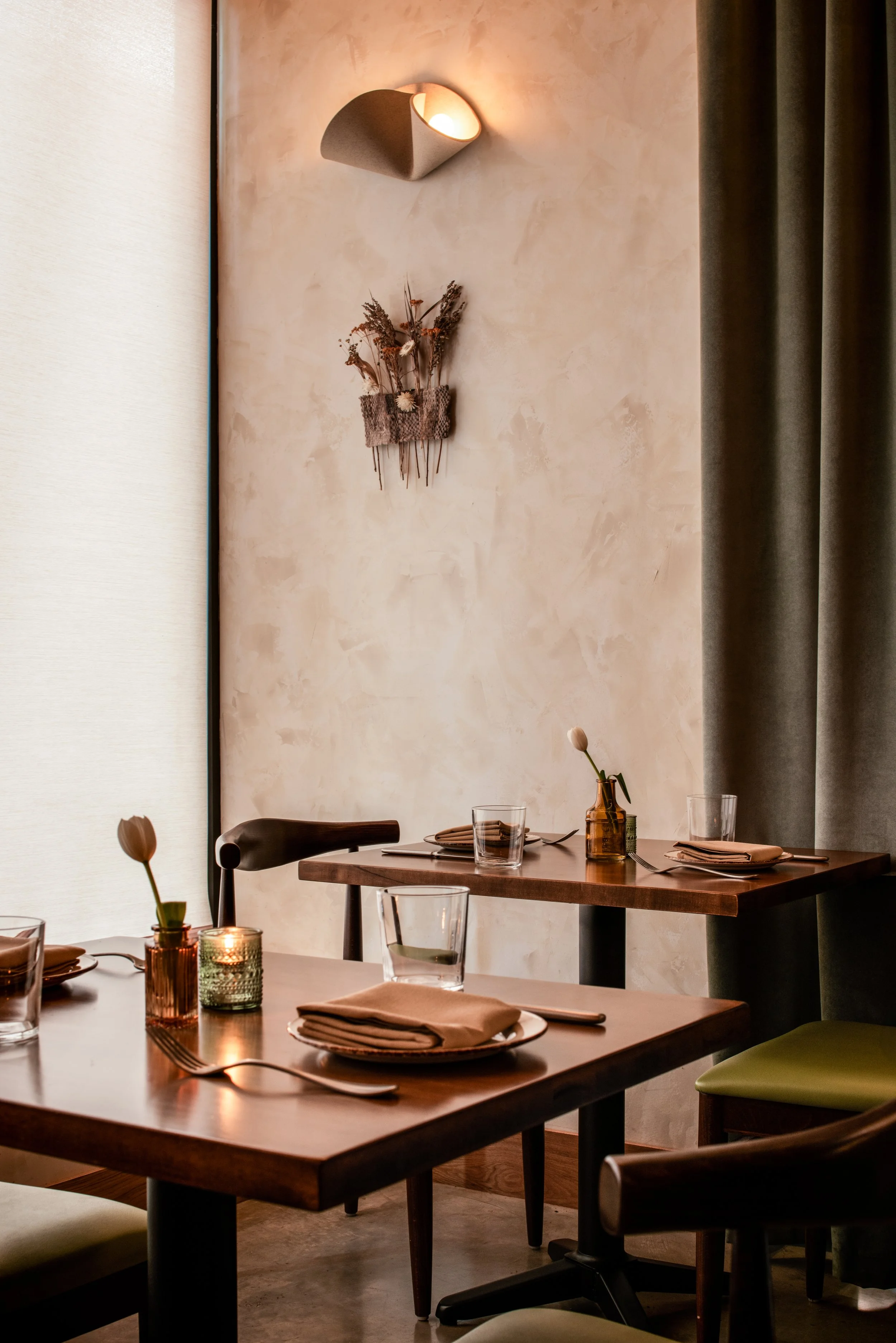 Burl dining room with textured plaster walls, walnut tables, sculptural lighting, and hospitality interiors by Siren Betty Design.