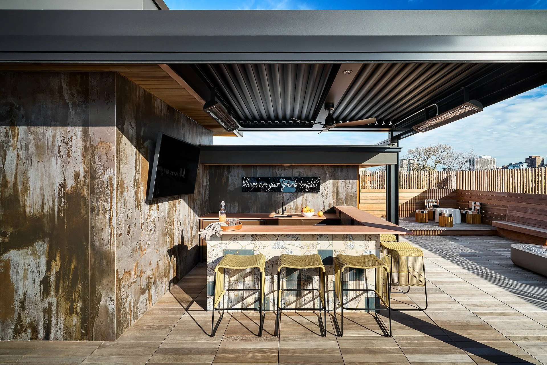 Private Residence rooftop bar with wood decking, marble counter and woven stools under open sky by Siren Betty Design.