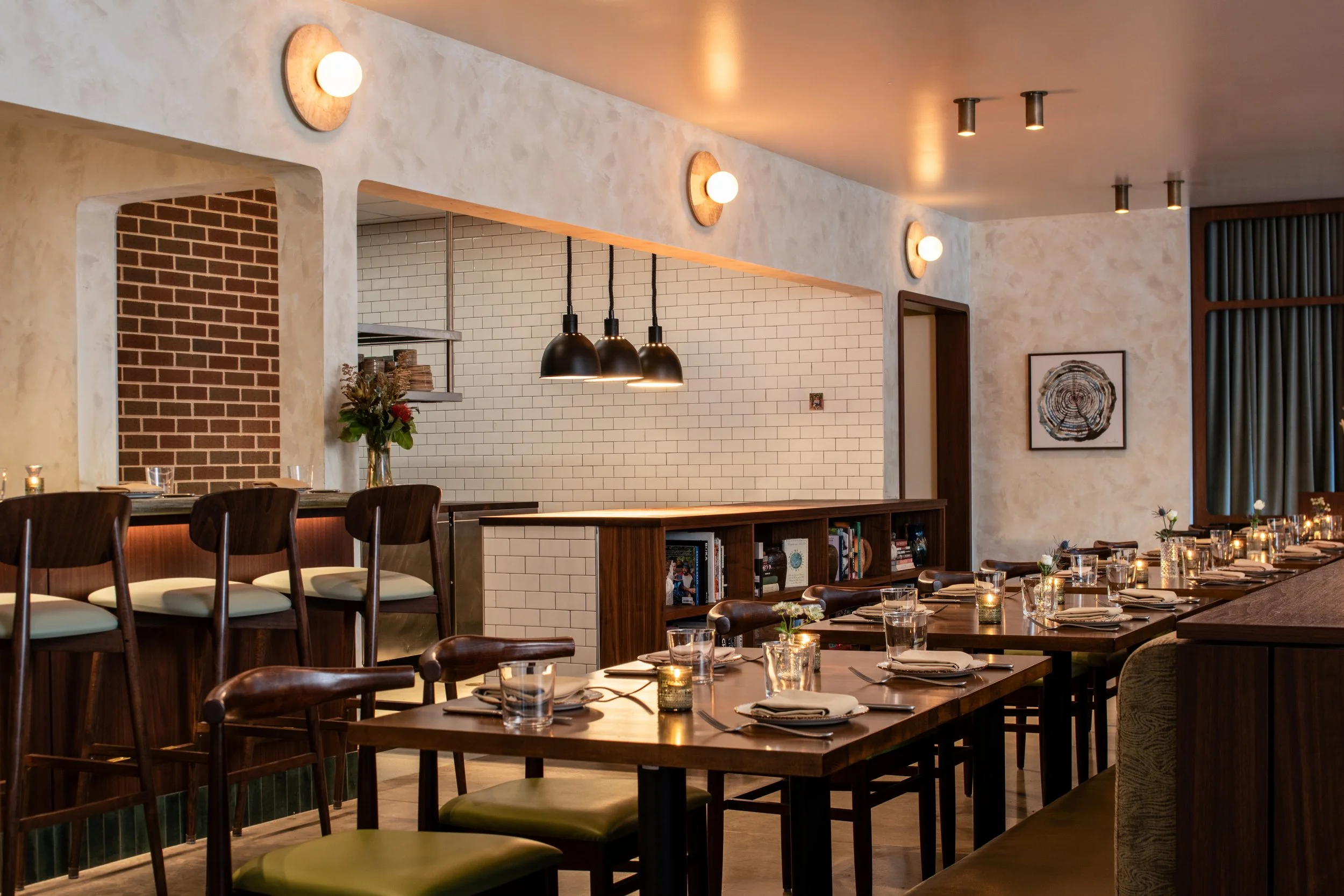 Burl main dining room with walnut tables, chartreuse seating, an open kitchen, and restaurant interior design by Siren Betty Design.