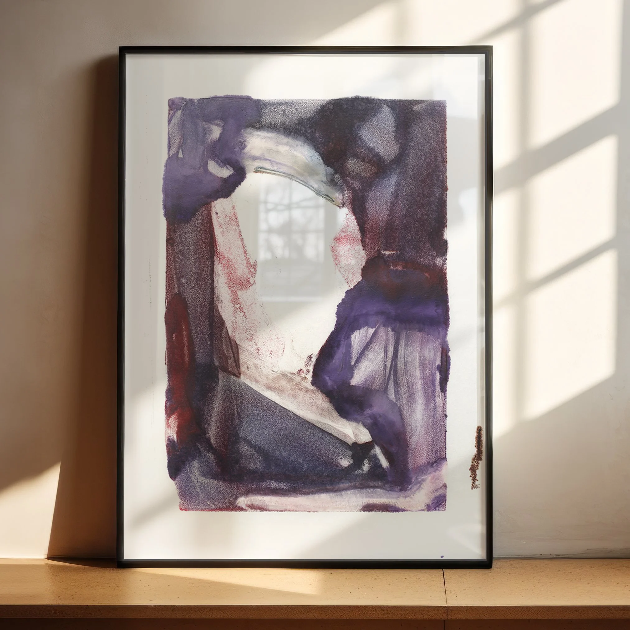 Dormancy by Melissa McGill displayed in a black frame on a sunlit wooden shelf, with violet and burgundy forms surrounding an open center beneath a curved gray-green passage.