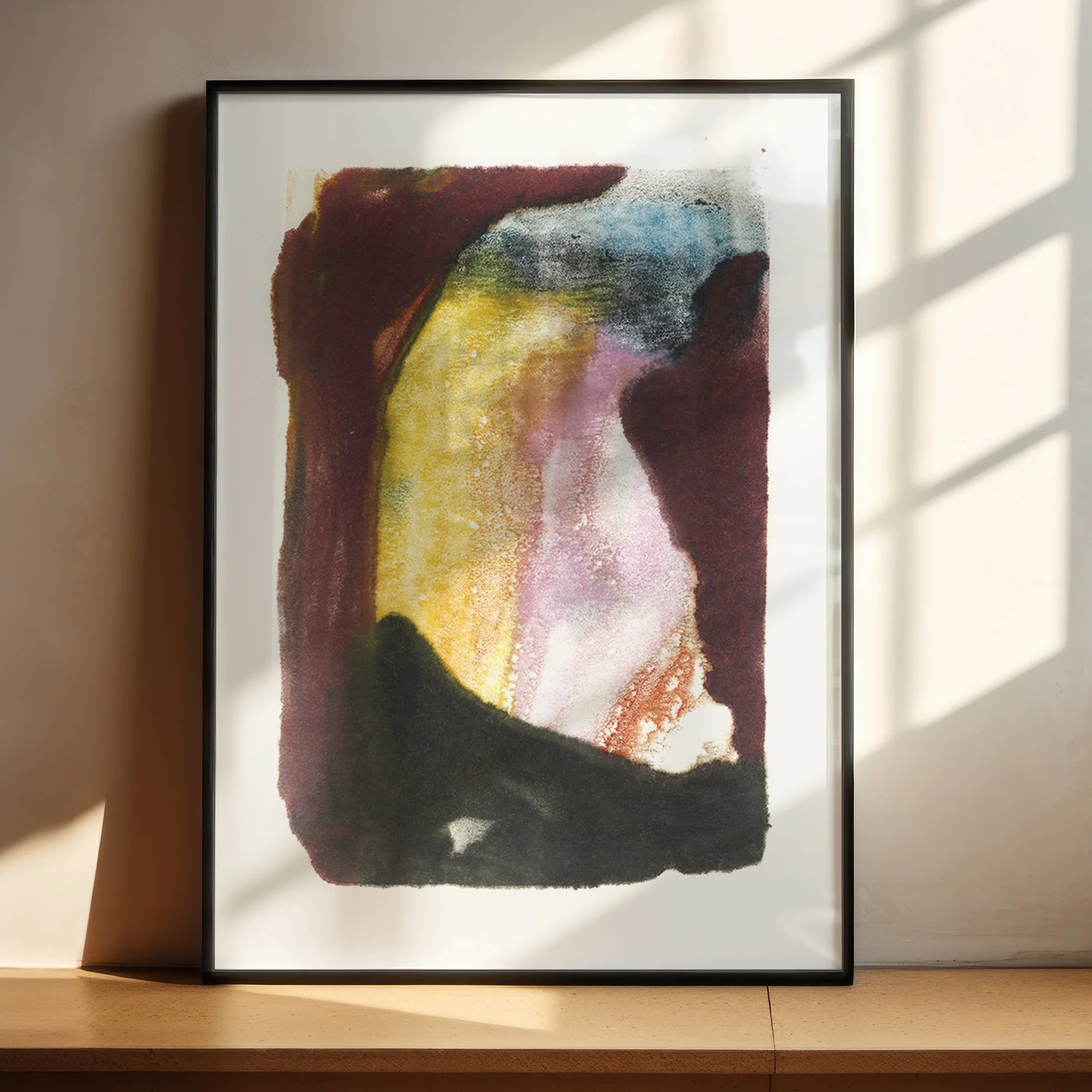 Refuge by Melissa McGill displayed in a black frame on a sunlit wood shelf, with deep burgundy and charcoal surrounding yellow, pink, blue-gray, and green forms.