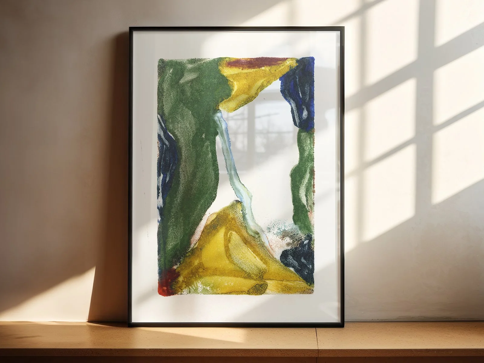 Headwaters by Melissa McGill displayed in a black frame on a sunlit shelf, with green and ochre fields surrounding a narrow pale blue passage.