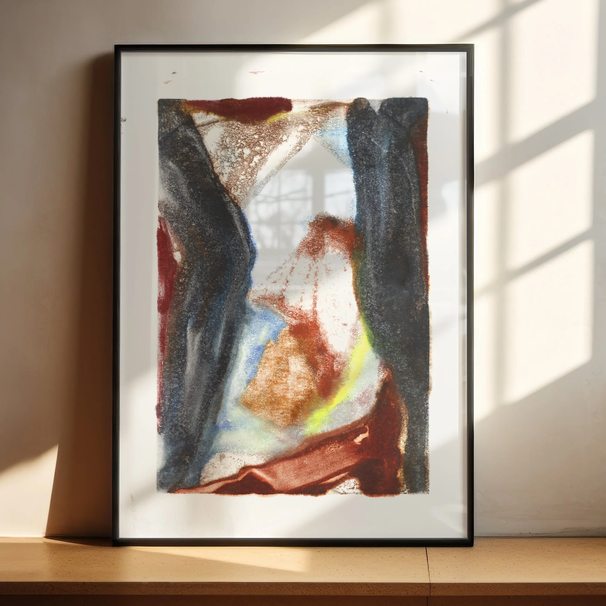 Divide by Melissa McGill displayed in a black frame on a sunlit wood shelf, with charcoal vertical forms surrounding rust, blue, turquoise, and yellow-green passages.