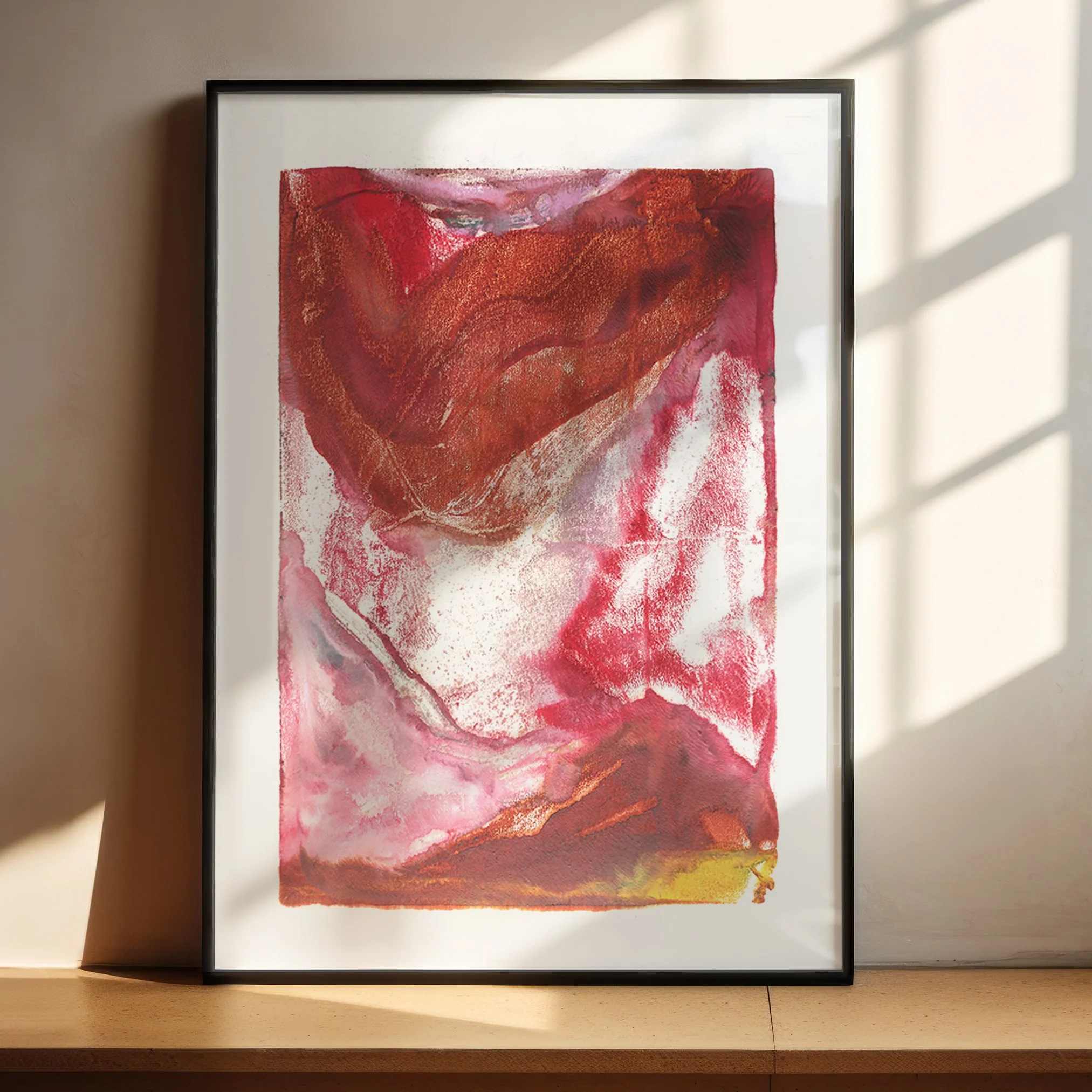 Thermal by Melissa McGill displayed in a black frame on a sunlit wooden shelf, with a sweeping burnt-orange upper field, crimson and rose passages, and a yellow accent along the lower edge.