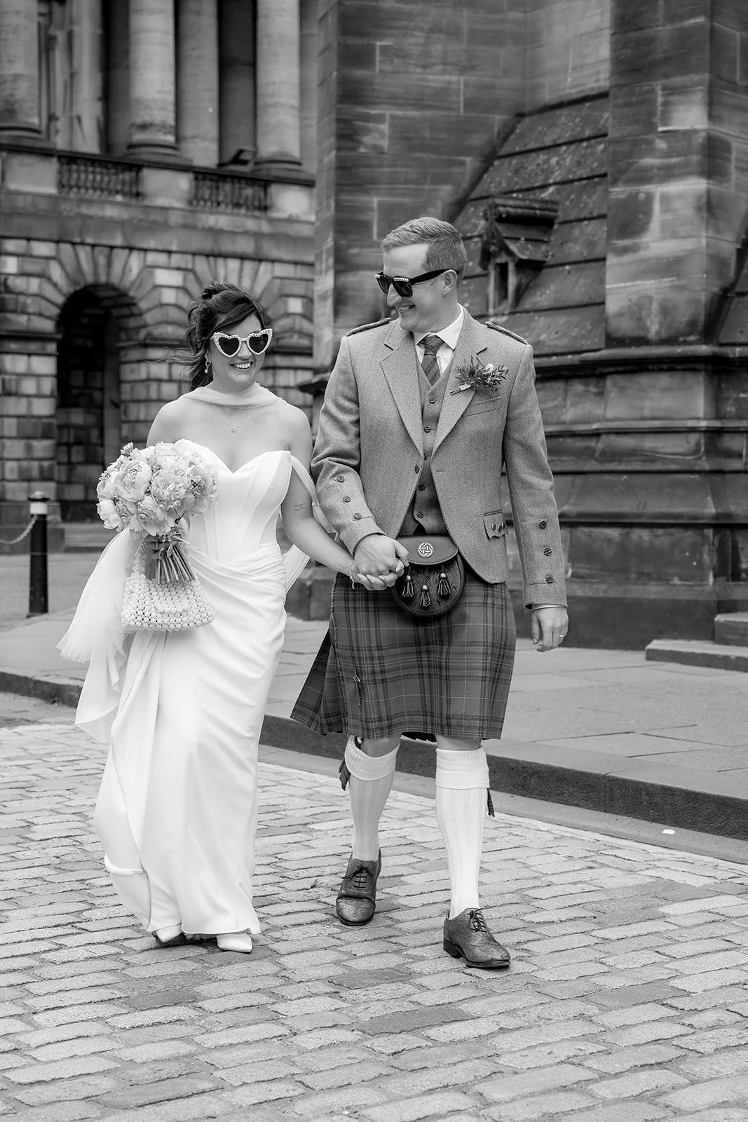 Bride and groom walking on Edinburgh's Royal Mile.