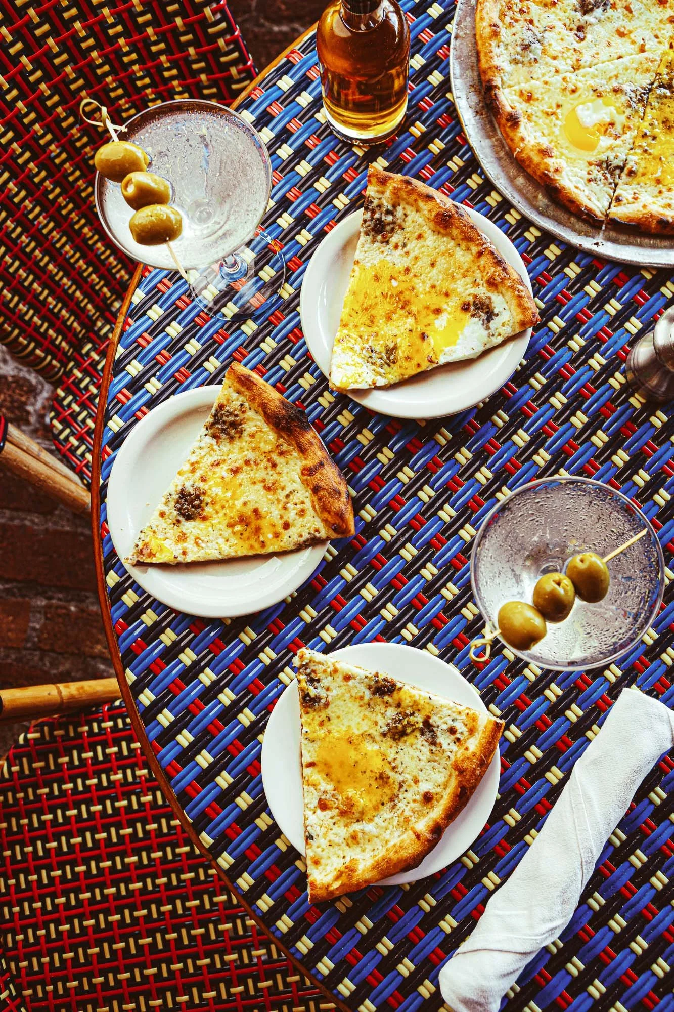 Restaurant dining experience photography featuring pizza and cocktails shared on a table in Miami.