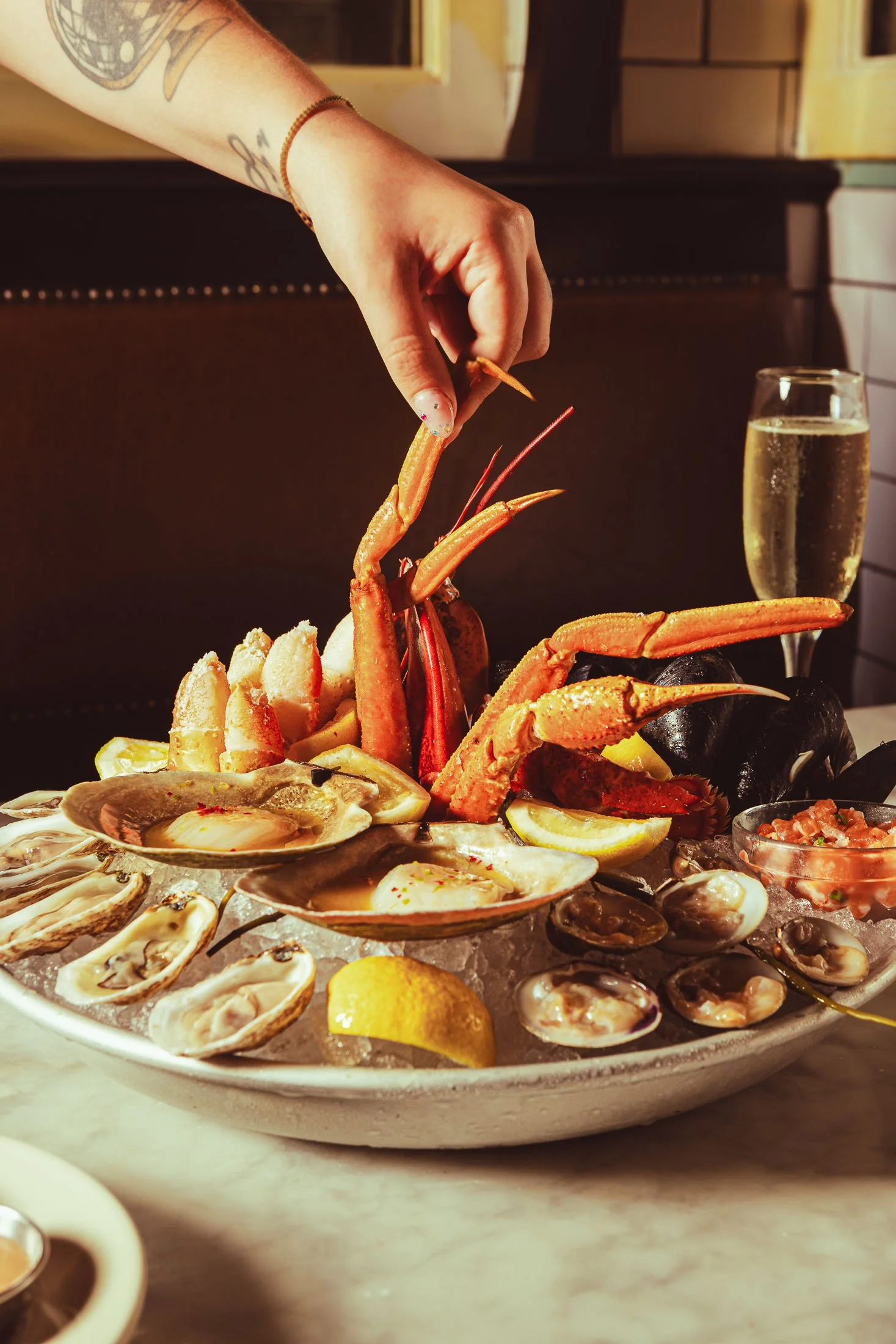 Fine dining seafood platter photography at Pastis Miami featuring oysters and crab legs in a French raw bar style