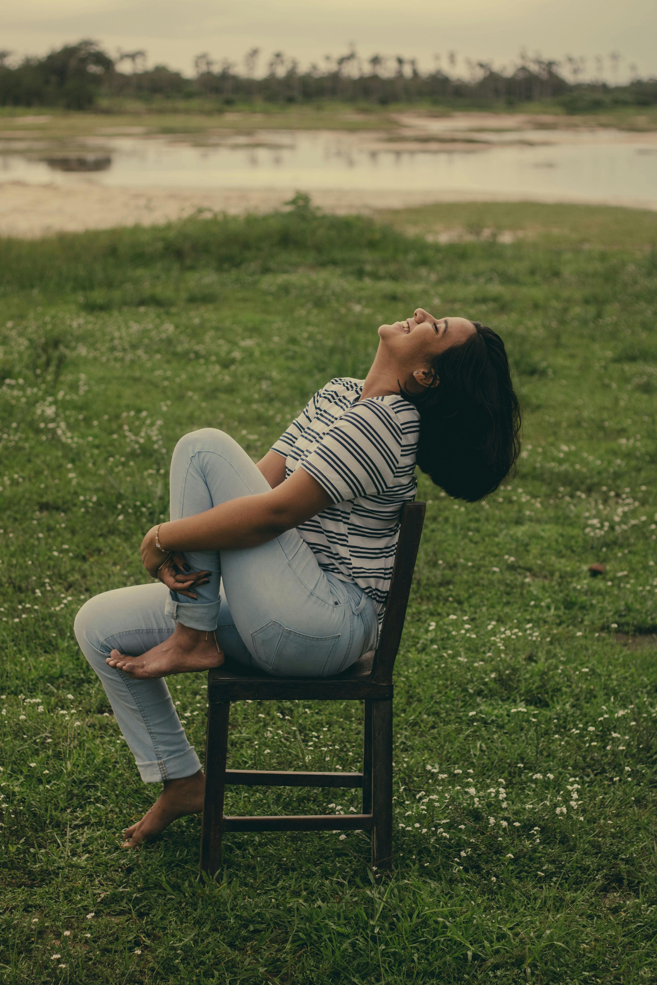 woman leaning back and smiling in warm sunlit  outdoors, representing online therapy for perimenopause and menopause in California