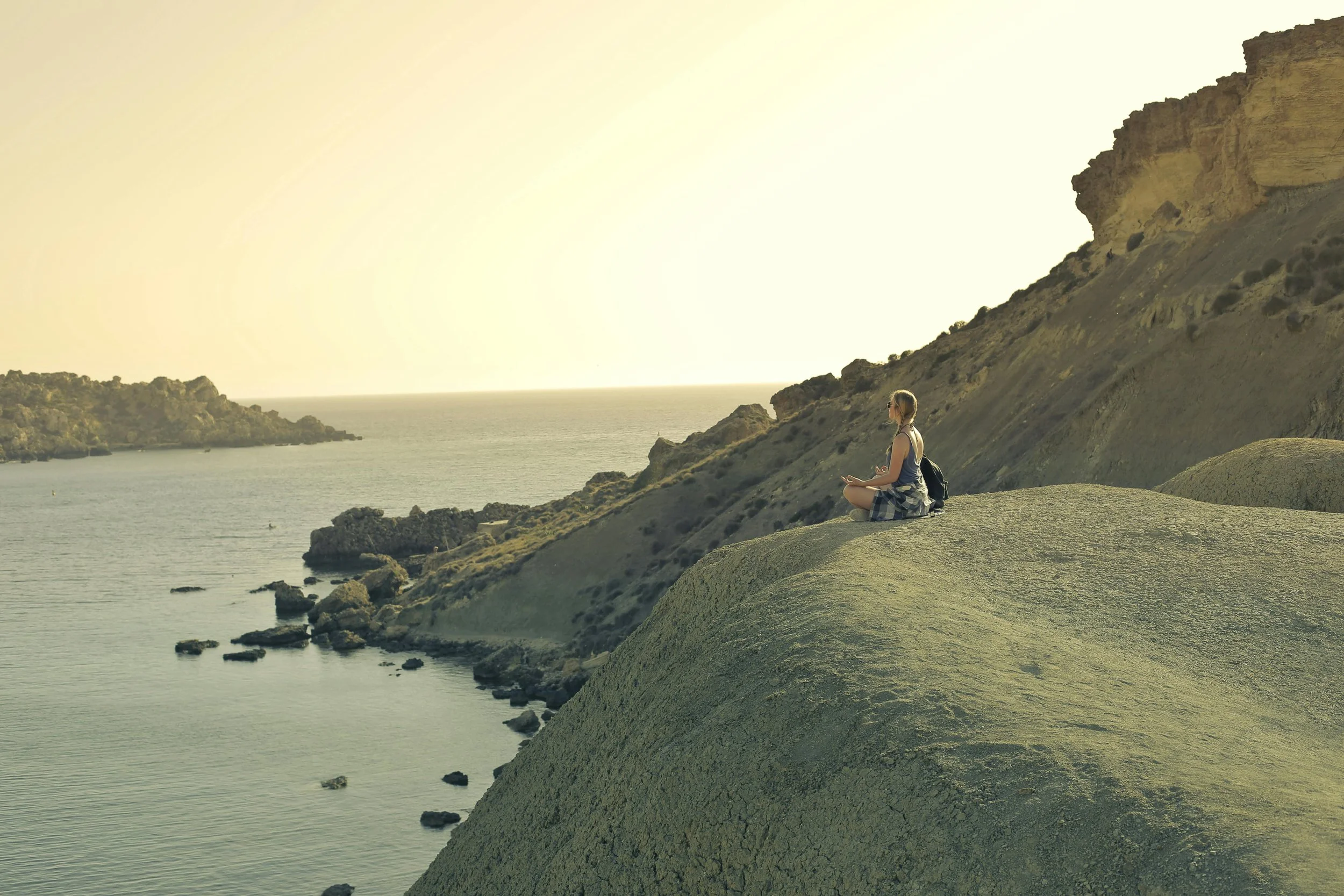 Woman sitting at the edge of an open landscape, representing the transformative transition of perimenopause and menopause therapy in California