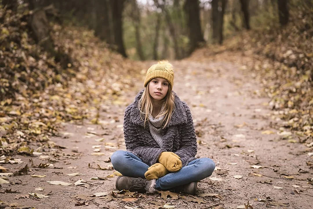 Fall image of girl in woods sitting Grand Rapids Michigan Fashion Brand Photography