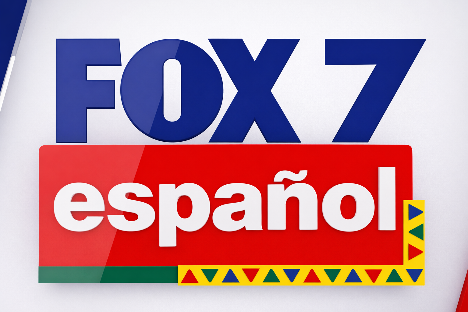 A colorful sign with the text 'FOX 7' in blue at the top and 'español' in white on a red background below, featuring a decorative border with yellow, green, red, and blue triangles.