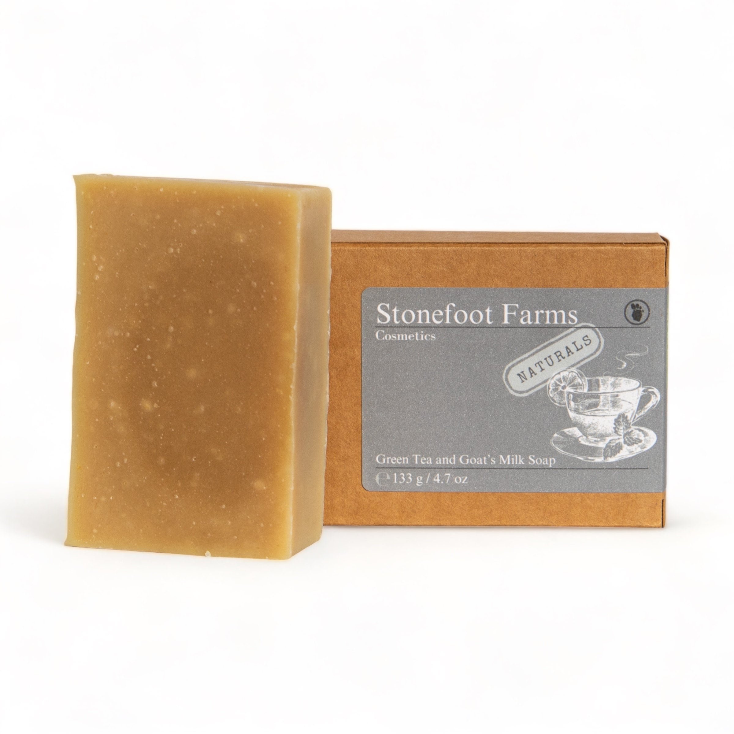 A bar of Stonefoot Farms Green Tea and Goat's Milk Soap positioned next to its earth-toned box, showcasing the soap's smooth texture and the natural essence of the ingredients.