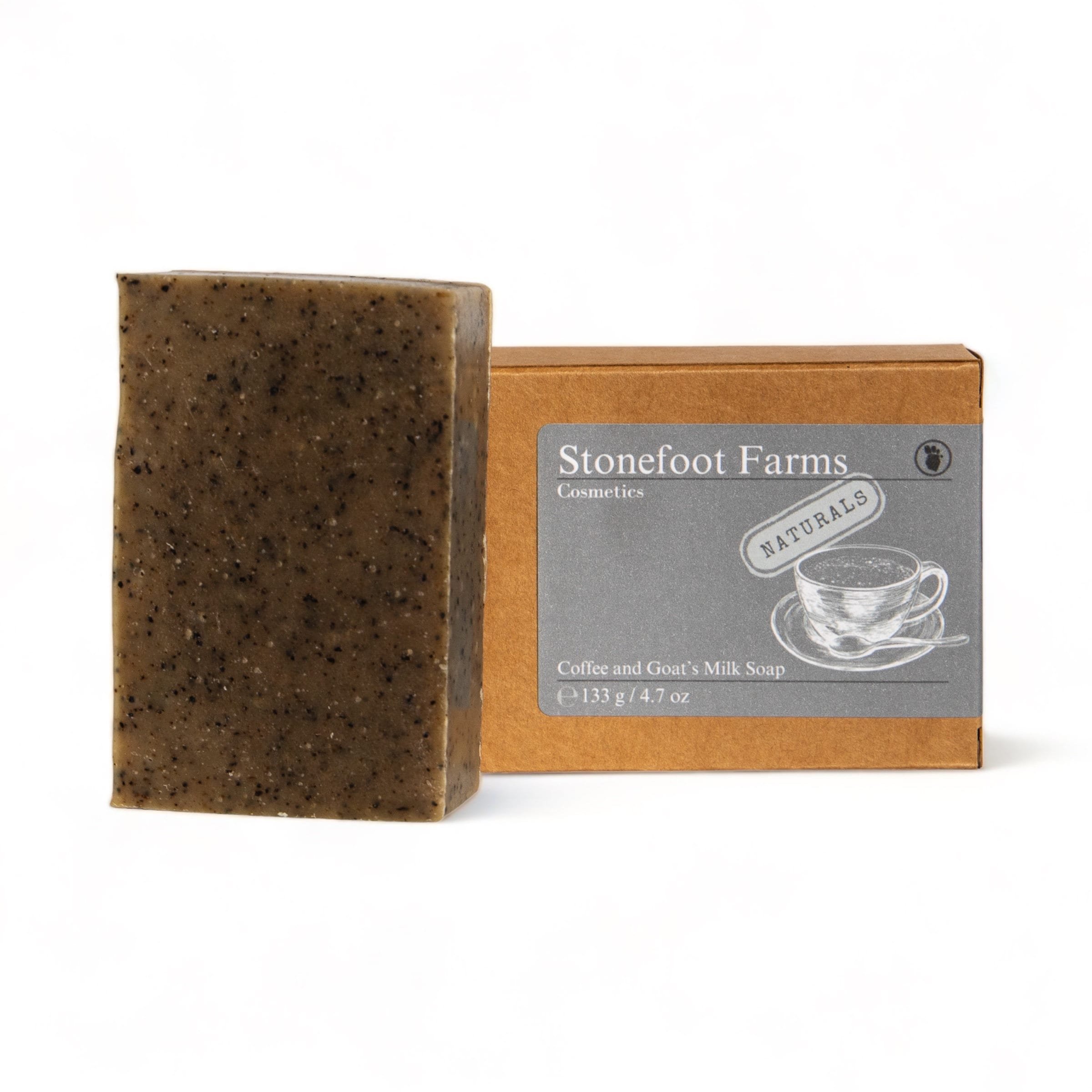 A bar of Stonefoot Farms Coffee and Goat's Milk Soap next to its packaging, highlighting the exfoliating texture and natural ingredients, perfect for a rejuvenating skincare routine