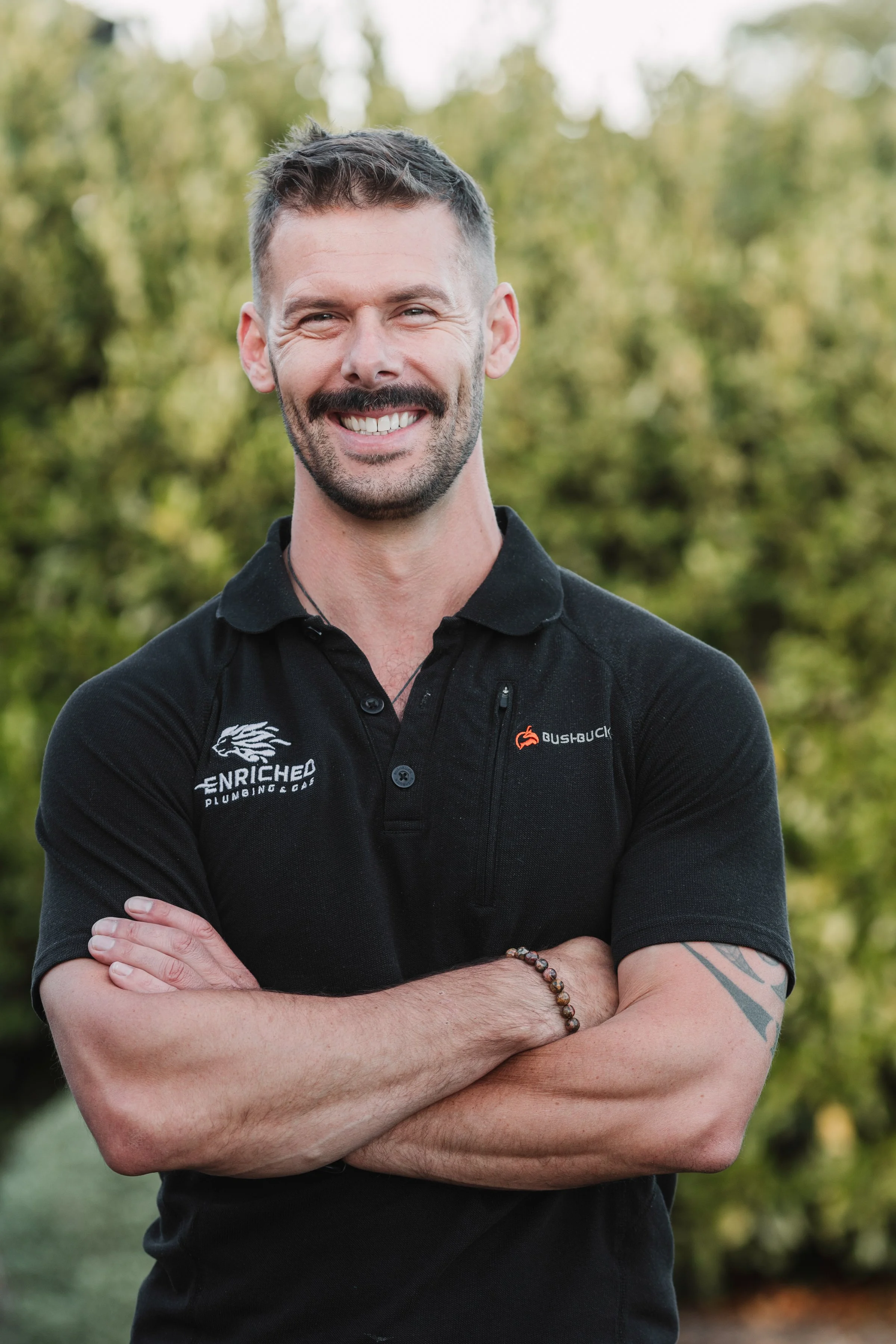 Portrait of Rich from Enriched Plumbing & Gas wearing company uniform outdoors.